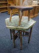 An Eastern octagonal folding brass top table and a rustic stool