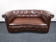 An early 20th century shaped brown button leather settee