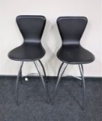 A pair of black leather chrome bar stools
