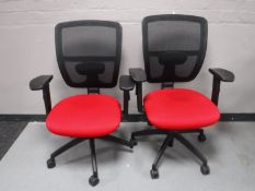 A pair of ergonomic office armchairs