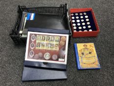 A crate containing several albums of British and foreign coins,