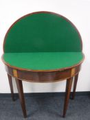 A George III inlaid mahogany demi lune games table