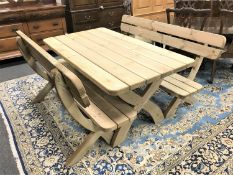 A pine fixed position garden dining table and two benches on x-frame support, table length 160 cm.
