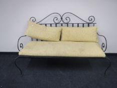 A wrought iron framed garden settee