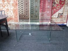 A large rectangular glass coffee table on two pedestals
