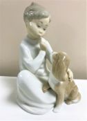 A Lladro figurine : Boy with Dog, model 4522, height 19 cm, boxed.