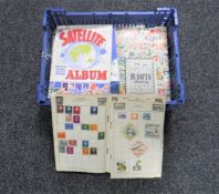 A basket containing eleven assorted mid 20th century stamp albums with stamps