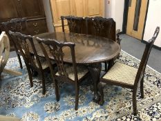 A late Victorian carved mahogany extending oval dining table, with leaf and winder,