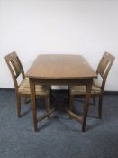 An early 20th century continental dining table and two chairs
