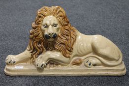 A 19th century Staffordshire glazed earthenware flat back figure of a lion CONDITION