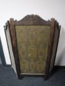 An antique carved oak three fold screen
