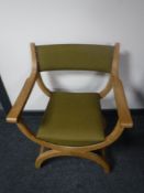 A continental blonde oak X frame armchair