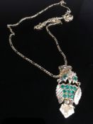 An 18ct owl pendant set with emerald and chain. 12.