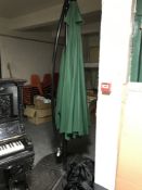 A garden canterleaver parasol on stand and stand weights