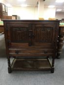 An oak double door linen fold cabinet
