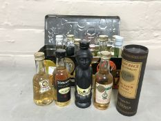 A tin containing a quantity of miniature alcohols including Glenmorangie Malt Scotch etc
