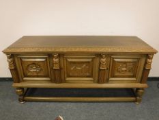 A continental carved oak low sideboard,