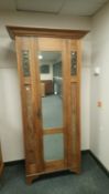 An Arts & Crafts oak mirror door wardrobe inset with copper panels, width 92.