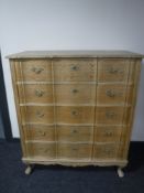 A continental blonde oak serpentine fronted chest drawers