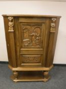 A continental carved oak corner cabinet