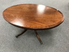 An oval inlaid mahogany pedestal coffee table
