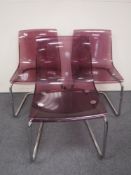 Three purple Perspex dining chairs on metal bases