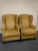 A pair of mid 20th century wing back armchairs in gold fabric