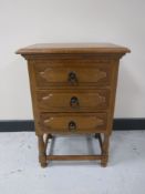 An oak three drawer bedside chest