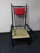 A 20th century ebonised spindle back rocking chair