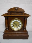 An Edwardian oak bracket clock with pendulum and key