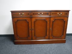 An inlaid mahogany Regency style triple door sideboard