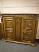 A continental carved oak side cabinet,