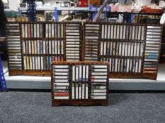 Three Eastern hardwood brass inlaid cassette tape racks containing tapes