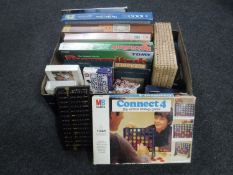 A box of assorted board games and jigsaws