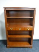 A set of open bookshelves fitted three drawers in a mahogany finish