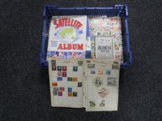 A basket containing eleven assorted mid 20th century stamp albums with stamps