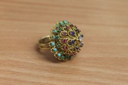 A high carat gold multi-gemstone ring, set with tiers of turquoise, emeralds, rubies,