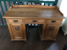 An early twentieth century light oak pedestal desk
