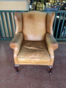 A tan leather club armchair