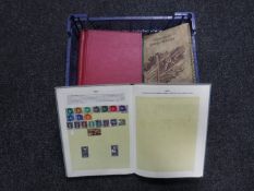 A basket containing six assorted mid 20th century stamp albums with stamps