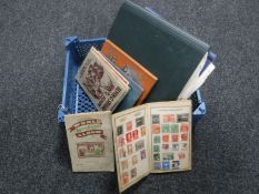 A basket containing seven assorted mid 20th century stamp albums with stamps together with two