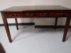 A reproduction mahogany leather topped desk