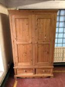 A pine double door wardrobe fitted with two drawers