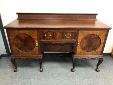 A carved mahogany pedestal sideboard fitted with a drawer