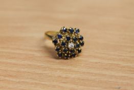 An 18ct gold sapphire and diamond cluster ring, 7.