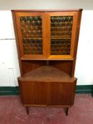 A mid 20th century teak glazed corner cabinet