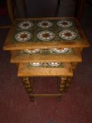 A nest of three oak tiled tables