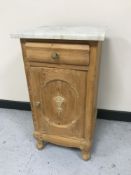 A white marble topped bedside cabinet and a four drawer bow-fronted chest