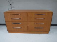 Four piece G-plan bedroom suite comprising of eight drawer chest, headboard,