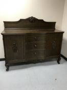 An early 20th century oak serpentine fronted sideboard